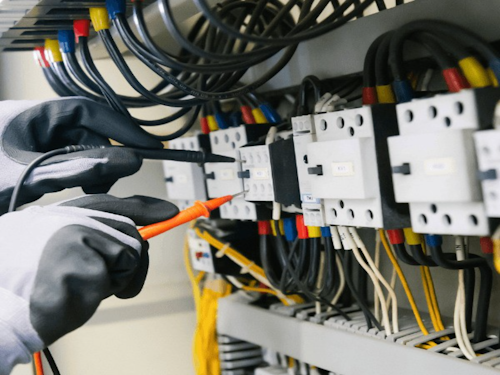 Electrician testing a panel with a multimeter